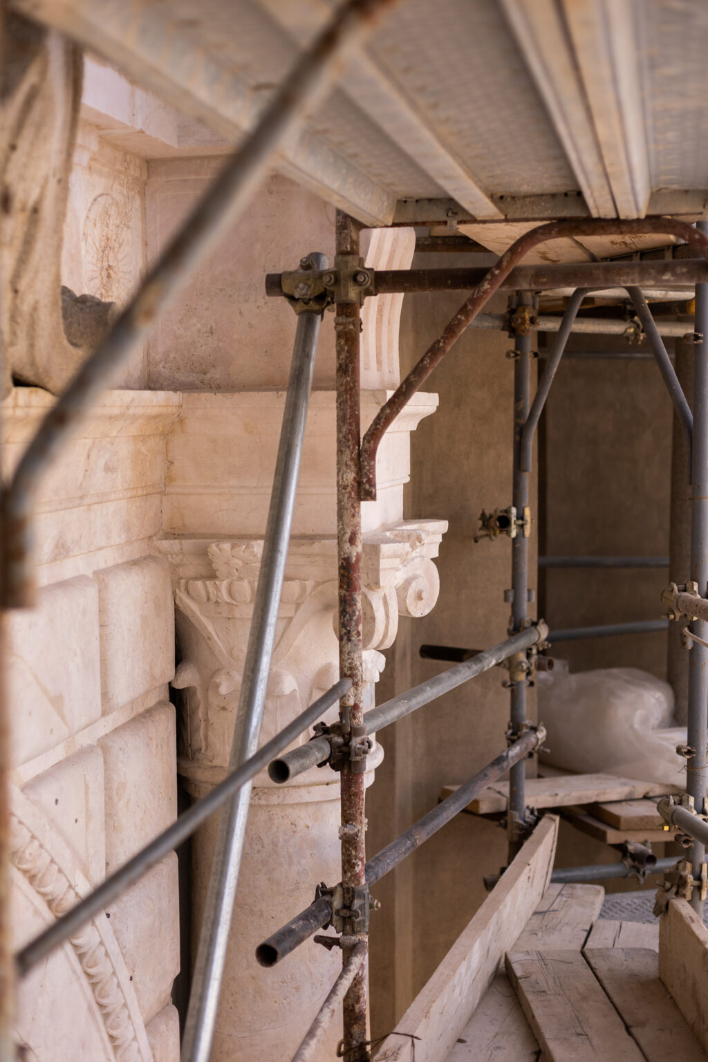 a metal scaffolding on an old antique italian building with sculptures
